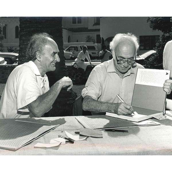 Chillida and Peter Selz signing books at the symposium about his work at the La Jolla Museum of Contemporary Art